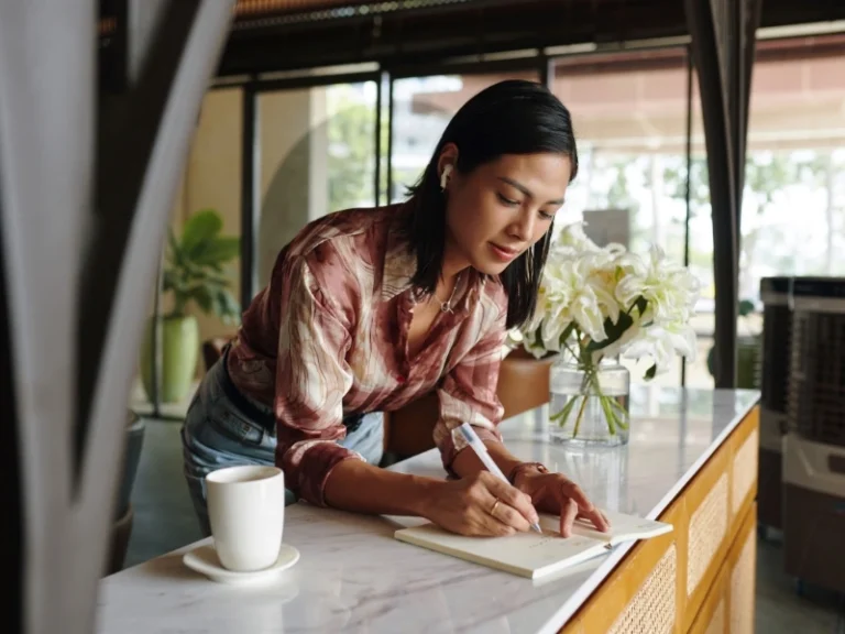 Female entrepreneur writing ideas in notebook. Image highlights common tax errors for small businesses, tax mistakes startups make, tax pitfalls for entrepreneurs, and startup tax mistakes.