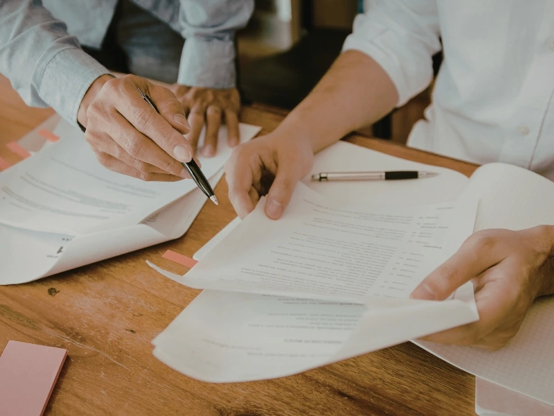 Couple reviewing documents on a table. Image highlights common tax errors for small businesses, tax mistakes startups make, tax pitfalls for entrepreneurs, and startup tax mistakes.