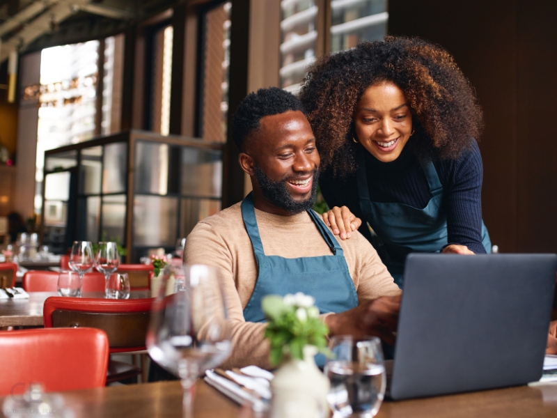 Married business owners looking at laptop. ements the blog addressing qualified join venture and married couple sole proprietorship or partnership. 