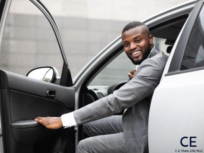 Man in a suit getting out of a car. Image complements the blog "can you write off lyft rides on your taxes?"