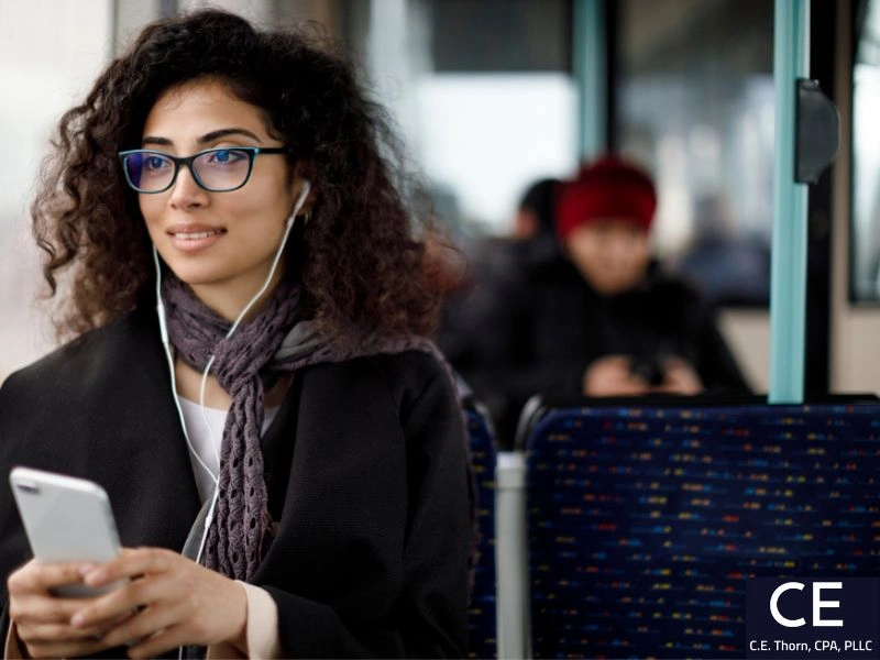 Woman wearing headphones on a bus. Image accompanies the question "is Uber tax deductible?" 