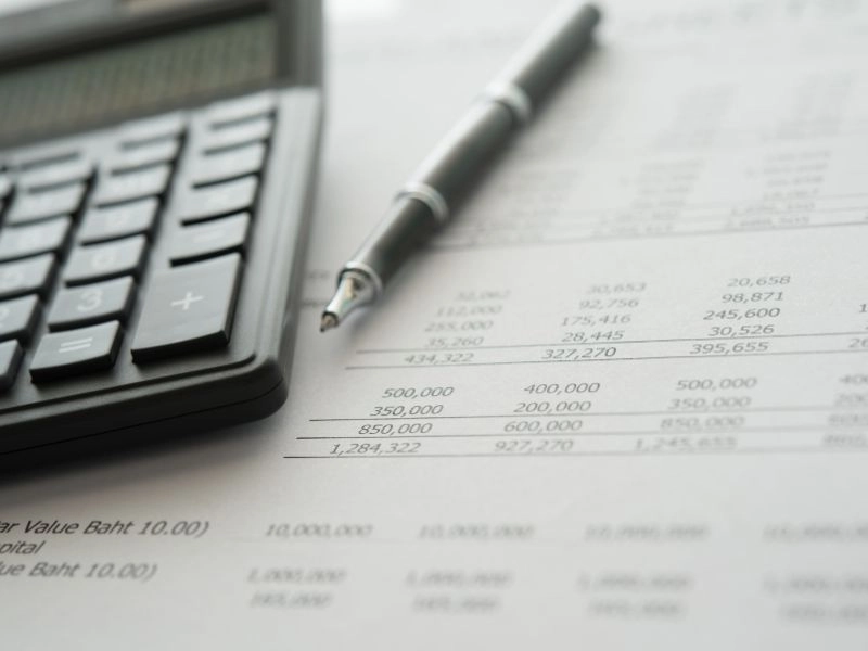 Financial statement with calculator and pen. Image complements the blog titled "Common Tax Mistakes."