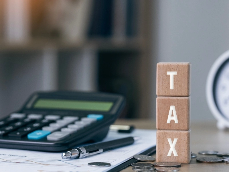 Calculator, tax blocks, highlighting the pros and cons of filing tax extension. 