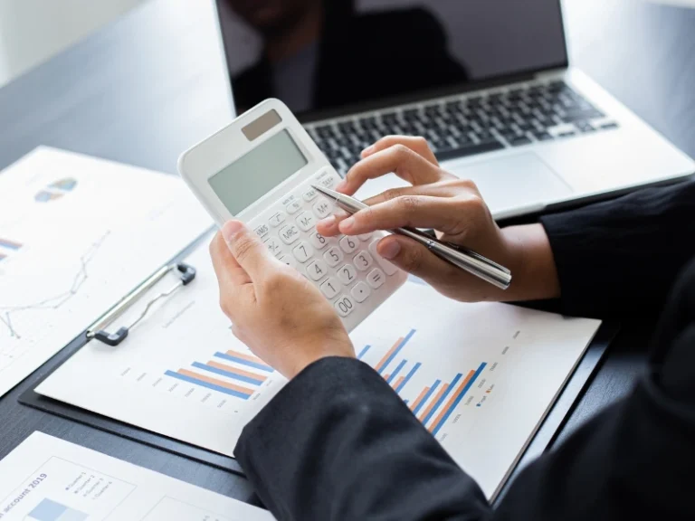 A man using a calculator. This image is for the blog titled "Small Business Tax Questions and Answers."