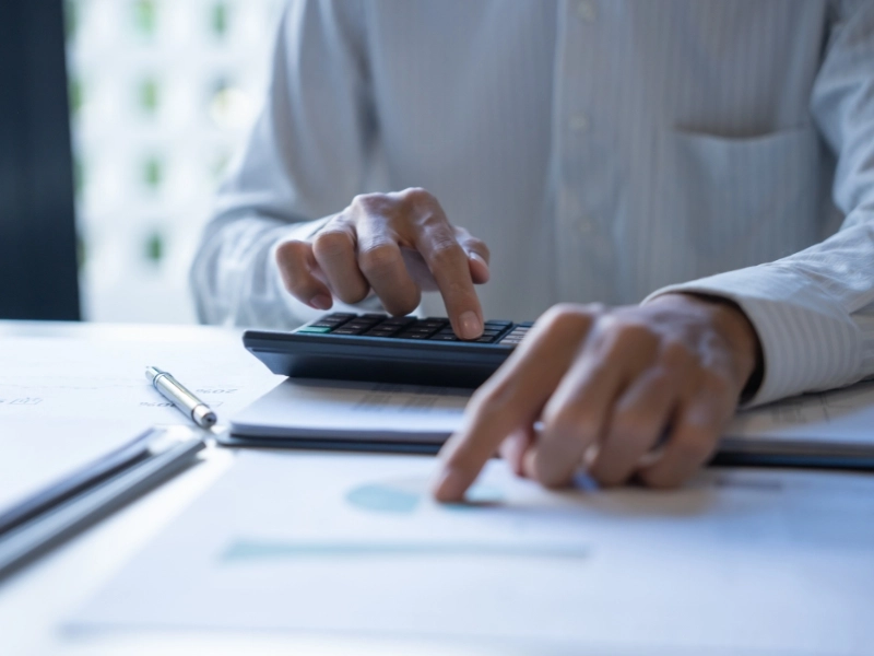 Male CPA categorizes business expense categories using calculator and list. business expense categories for taxes, typical small business expenses. 