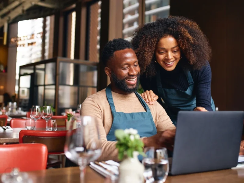 Married business owners looking at laptop. ements the blog addressing qualified join venture and married couple sole proprietorship or partnership.